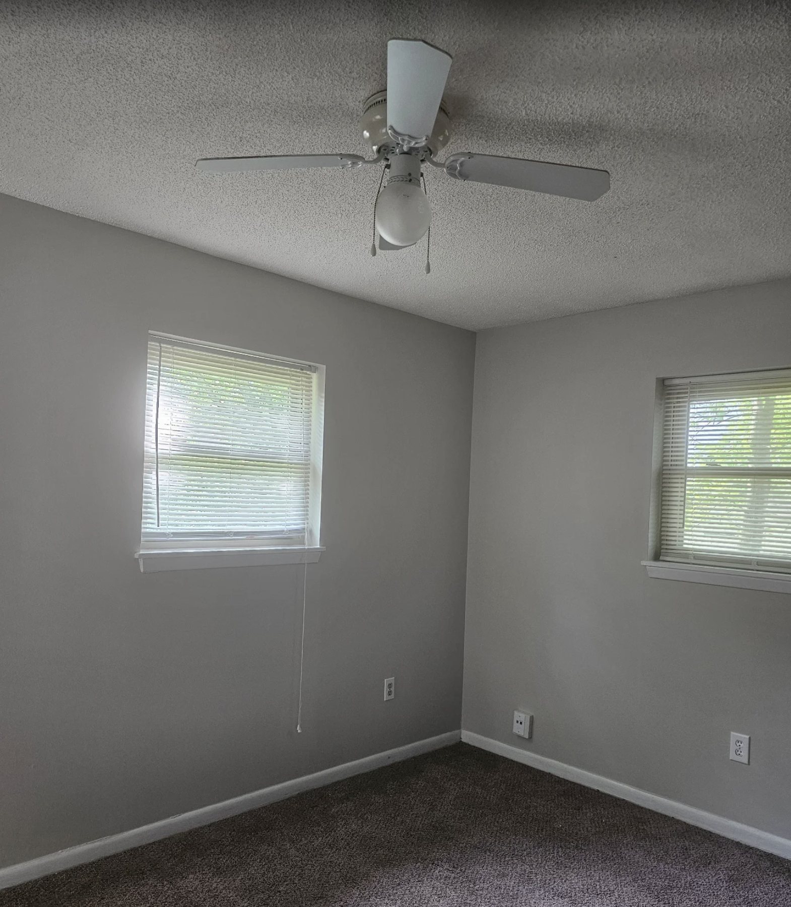 Bedroom repainted in soft grey with clean white trim and window casing