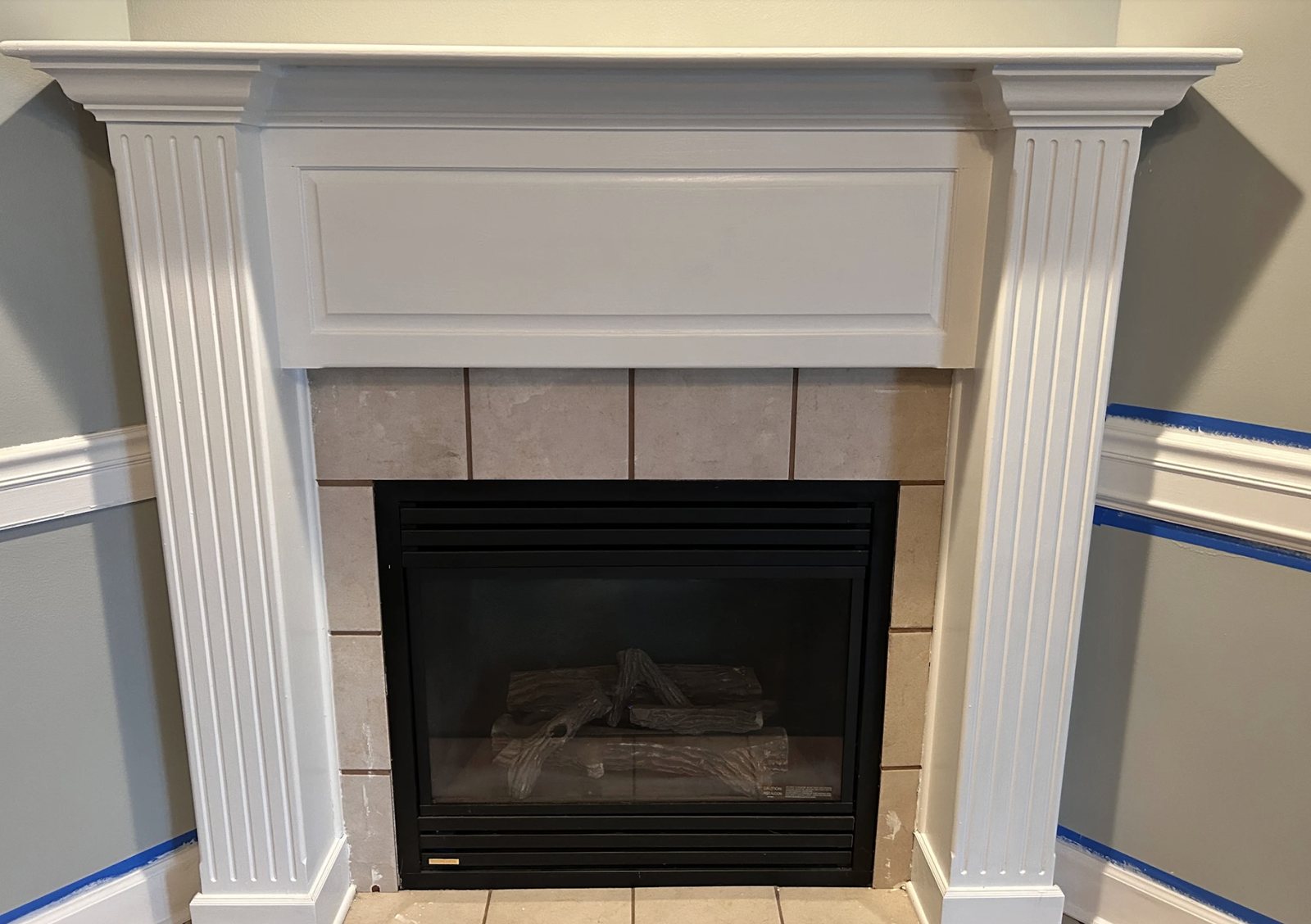 Fireplace mantel and surround masked with tape during trim painting