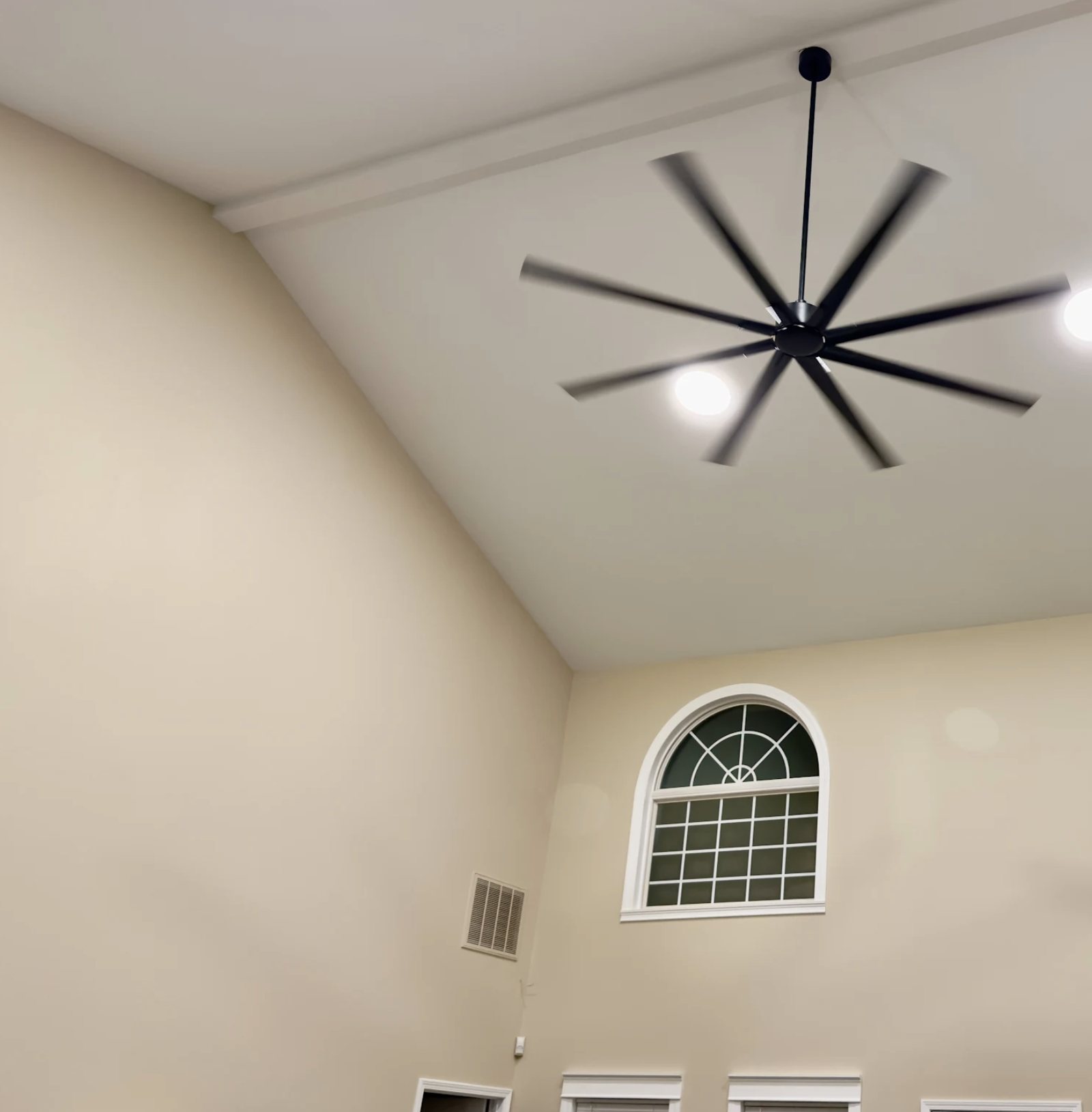 Vaulted living room ceiling and walls repainted around a black ceiling fan