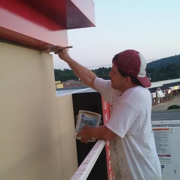 Matthew Evans of Mr. Paint cutting in fascia by hand on a commercial building in Little Rock